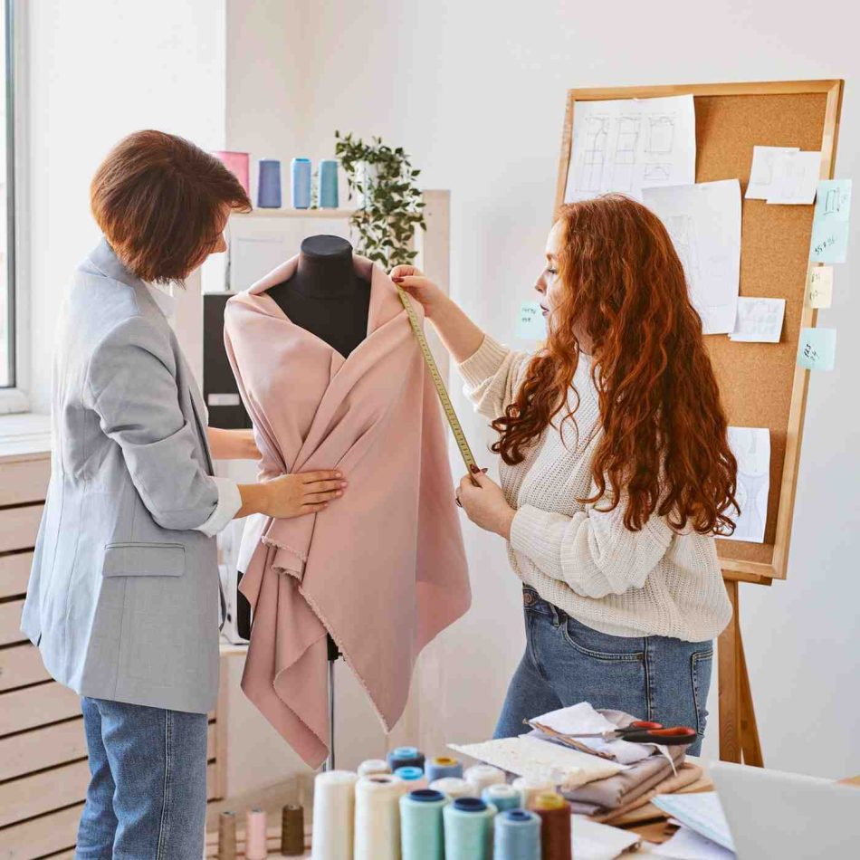 female-fashion-designers-working-atelier-checking-garment-dress-form (1)